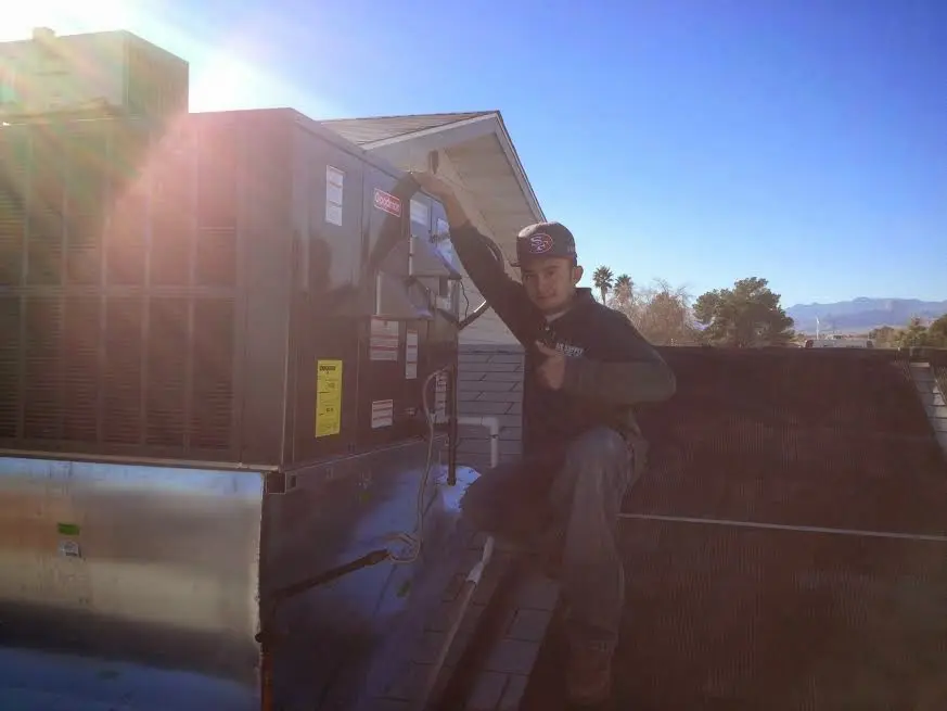 HVAC technician performing Heat Pump Repair on a rooftop unit in Bemidji